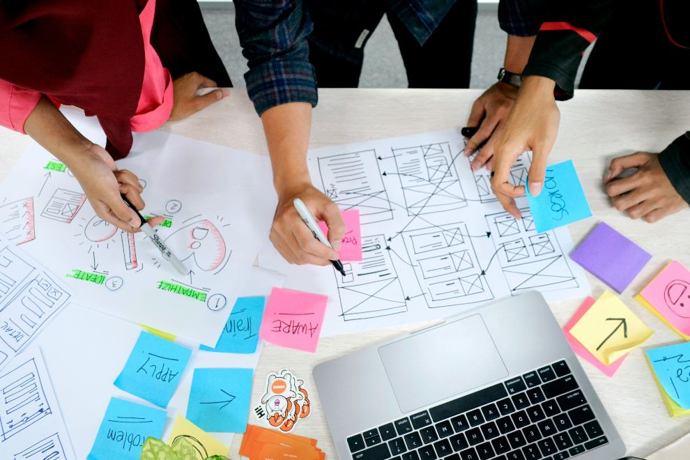 Planning a website build — sketching user flows and page layouts on paper